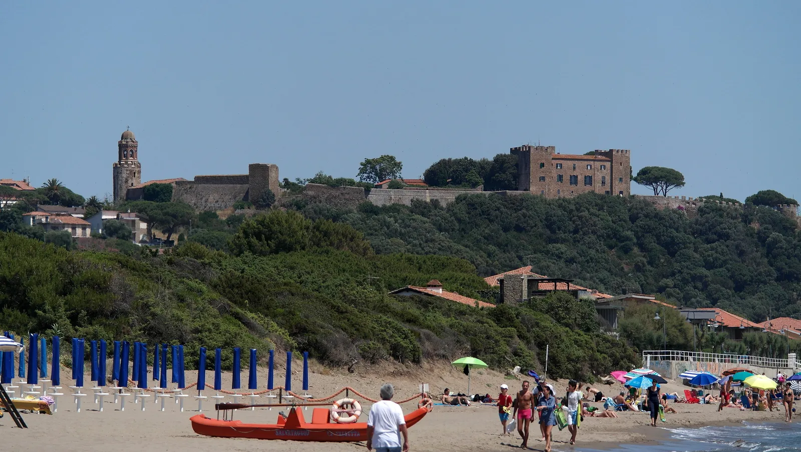 La spiaggia di Castiglione della Pescaia con il borgo medievale e il castello sulla collina