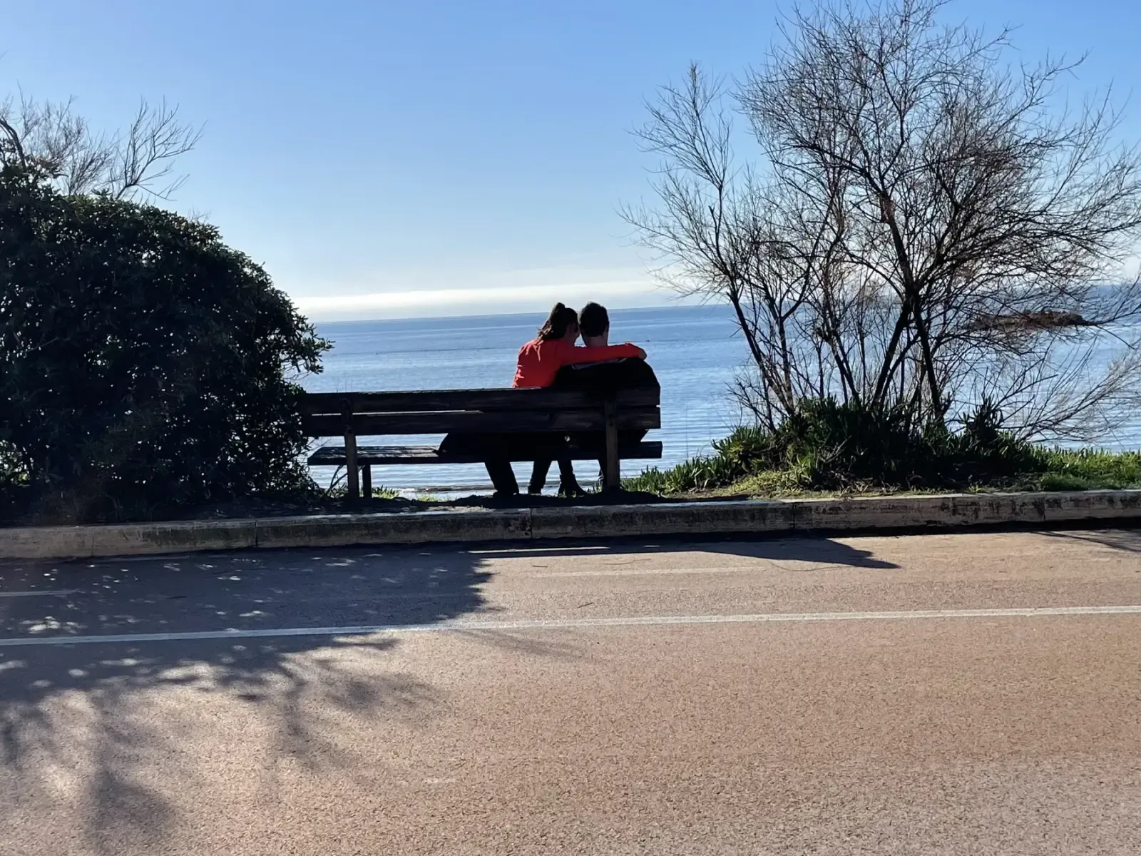 Una coppia seduta su una panchina davanti al mare sul lungomare di Pratoranieri