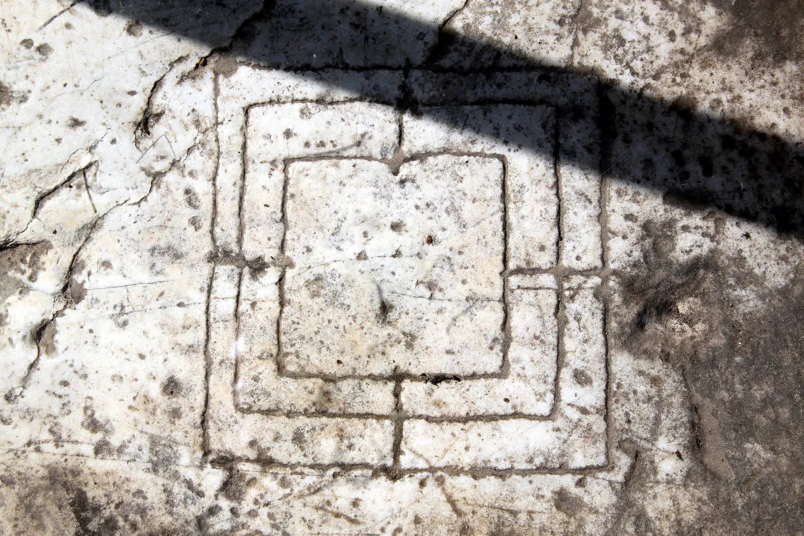 La griglia del gioco del filetto incisa su un gradino di pietra a Rocca San Silvestro
