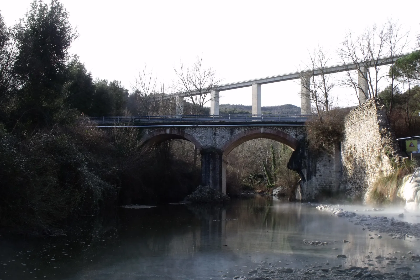 Il ponte antico e il vapore sopra il fiume ai Bagni di Petriolo