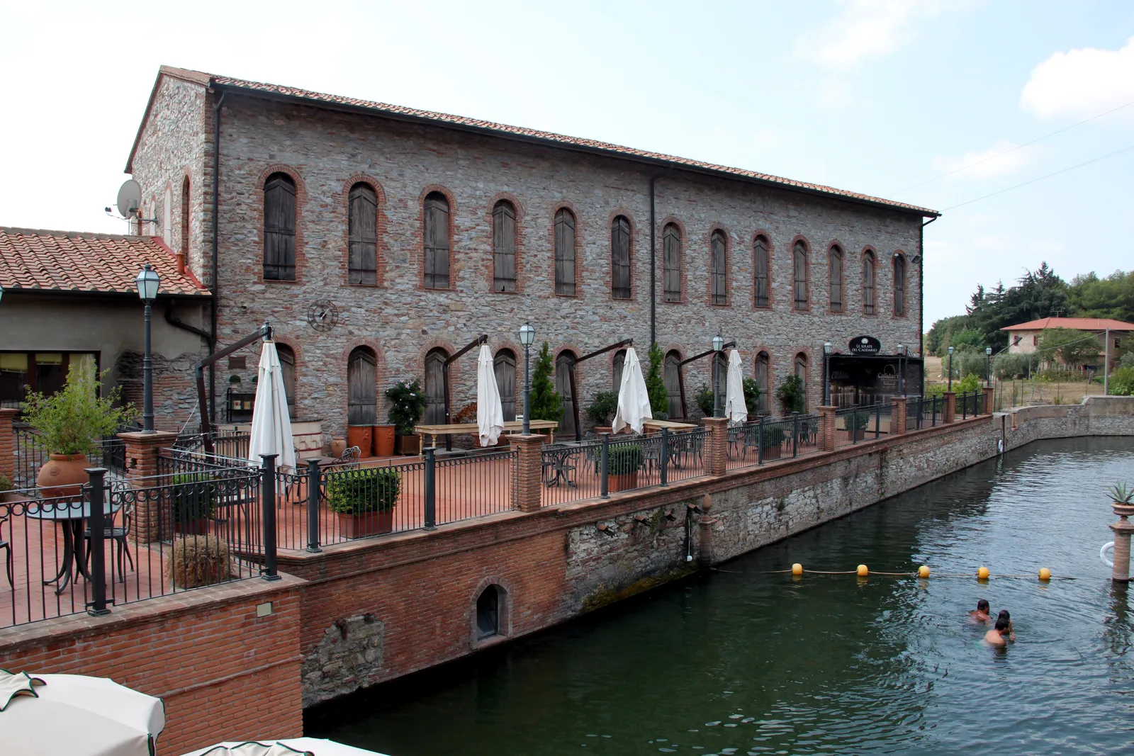 L’edificio storico in mattoni affacciato sul lago termale del Calidario