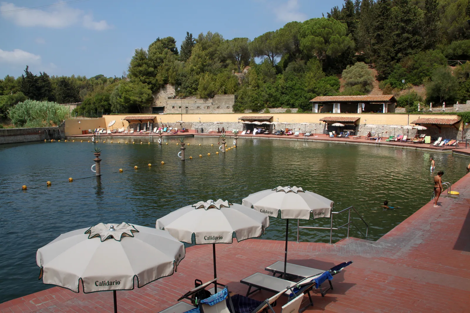 Il lago termale del Calidario di Venturina con ombrelloni e lettini